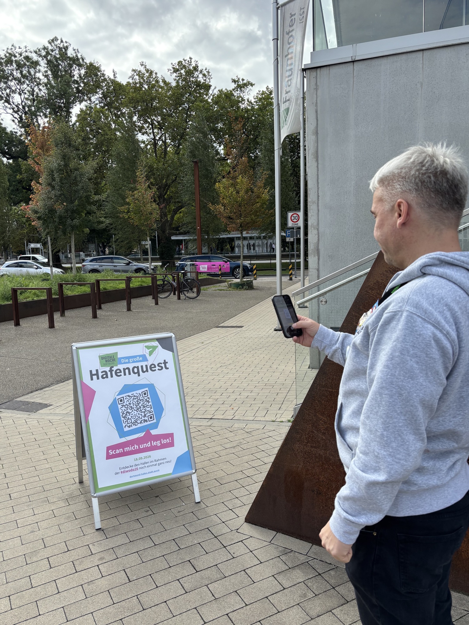 Besucher scannt am Dortmunder Hafen den QR-Code der digitalen Hafenquest